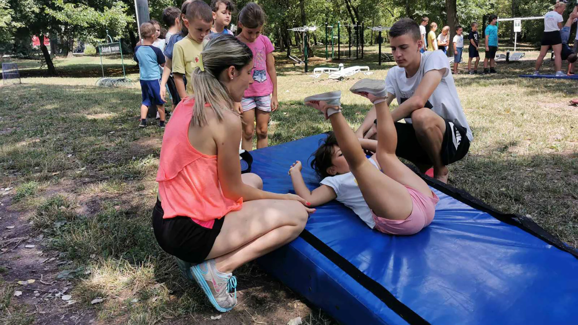 trener-radi-sa-detetom-kamp trener objašnjava zadatak detetu u kampu